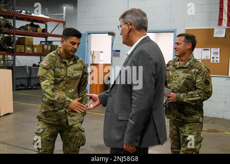 M. Devin L. Cate, directeur exécutif de la Air National Guard coins SSTGT. Rhett Romano, du vol de soutien aérien de 106th, avant une séance de questions-réponses avec des aviateurs au Groupe de soutien à la mission de l’escadre de sauvetage de 106th à la F.S. Base de la Garde nationale aérienne de Gabreski, plage de Westhampton, New York, sur 5 août 2022. (É.-U. Photos de la Garde nationale aérienne par le sergent d'état-major Daniel H. Farrell) Banque D'Images