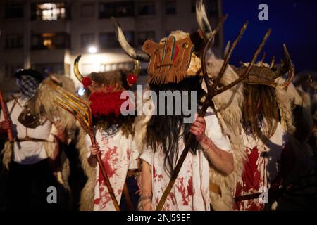 Alsasua/Altsasu. Navarre. Espagne. 21th février 2023. Traditions. Carnavals. Les Momotxorros, adultes et enfants, recouverts de sang animal et vêtus de cornes, de peaux et de leur grande fourche en bois, marchent dans les rues de la ville la nuit tombée en écartant tous ceux qui traversent leur chemin pendant le carnaval rural d'Alsasua (Altsasu au Basque) à Navarre (Espagne) sur 21 février 2023. Credit: Iñigo Alzugaray / Alamy Live News Banque D'Images