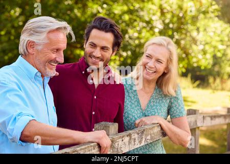 Famille souriante avec parents adultes et progéniture adulte sur la promenade dans la campagne Banque D'Images