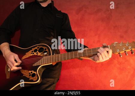 Vaduz, Liechtenstein, 13 janvier 2023 l'artiste se produit avec une guitare acoustique Ovation en rouge Banque D'Images