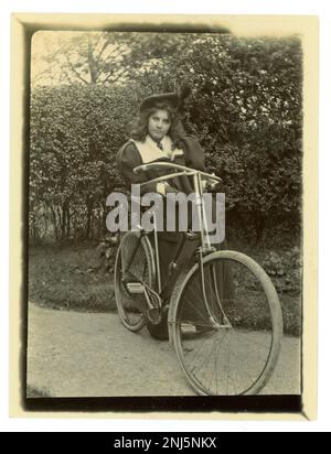 Photographie victorienne originale d'une adolescente avec son vélo dans un jardin, portant un béret, vélo vintage, vers 1897, fille victorienne. Région de Worcester, U. K Banque D'Images