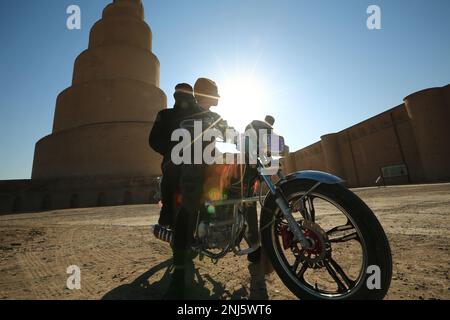 Samarra, Irak. 22nd févr. 2023. Un motocycliste court devant le Minaret de Spiral Malwiya, un monument national iraquien précieux du milieu du neuvième siècle. Credit: Ameer Al-Mohammadawi/dpa/Alamy Live News Banque D'Images