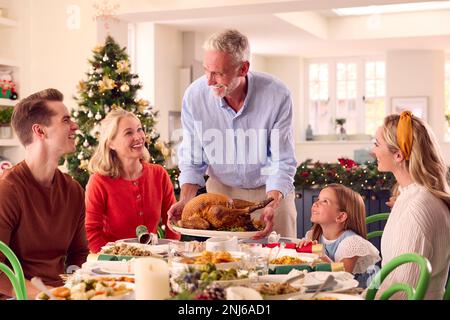 Famille de plusieurs générations célébrant Noël à la maison avec grand-père au service de la Turquie Banque D'Images