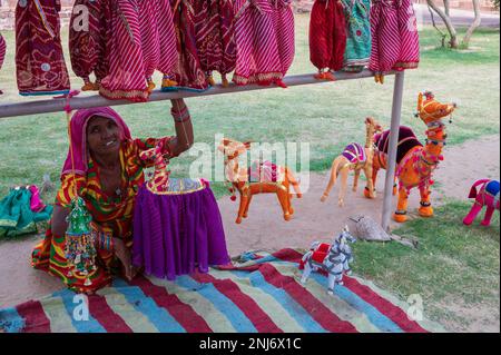 Jodhpur, Rajasthan, Inde - 19th octobre 2019 : ancienne femme Rajasthani âgée vendant des poupées colorées Rajaathani faites main de chameaux et de cheval. Rajasthan Banque D'Images