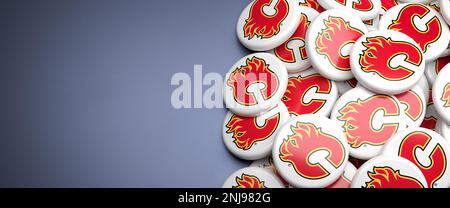 Logos de l'équipe LNH de l'American National Hockey League Calgary Flames sur un tas sur une table. Banque D'Images