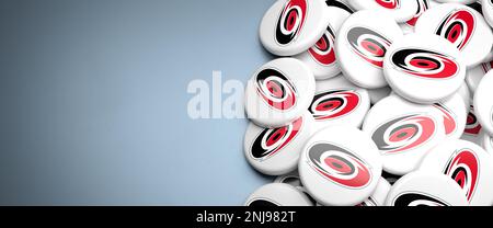 Logos de la Ligue nationale américaine de hockey NHL Team Carolina Hurricanes sur un tas sur une table. Banque D'Images