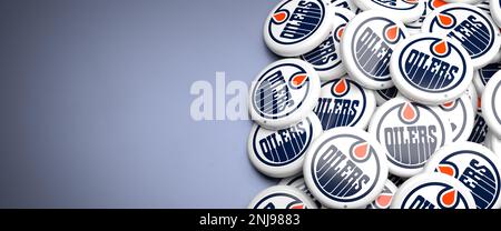 Logos de l'équipe LNH de la Ligue américaine de hockey les Oilers d'Edmonton sur un tas sur une table. Banque D'Images