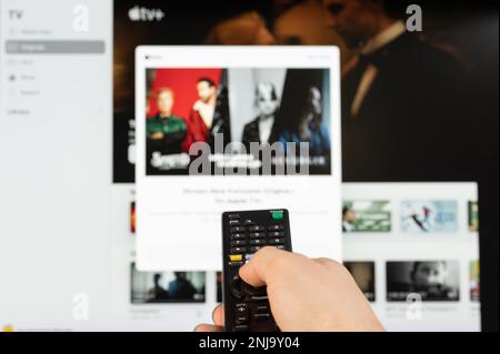 New york, Etats-Unis - 21 février 2023 : sélectionnez la vidéo sur l'Apple TV et diffusez le service sur le téléviseur avec télécommande en main Banque D'Images