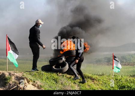 Gaza, bande de Gaza, Palestine. 22nd févr. 2023. Bande de Gaza, Palestine. 22 février 2023. Les Palestiniens brûlent des pneus et lèvent des drapeaux palestiniens lors d'une manifestation dans la région de Malika, près de la frontière orientale de la bande de Gaza. La manifestation a eu lieu pour condamner les raids militaires israéliens fréquents et en cours dans le nord de la Cisjordanie, en particulier à Naplouse et Djénine, effectués sous prétexte d'arrêter des Palestiniens recherchés (Credit image: © Ahmad Haaballah/IMAGESLIVE via ZUMA Press Wire), À USAGE ÉDITORIAL EXCLUSIF ! Non destiné À un usage commercial ! Banque D'Images