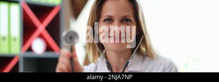 Une jeune femme médecin à l'hôpital tient le stéthoscope Banque D'Images