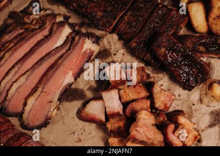 Une image en gros plan d'une feuille de papier émiettés avec des morceaux de saucisse et de steak disposés dessus Banque D'Images