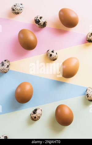 Œufs de poulet brun et blanc et œufs de caille sur fond multicolore Banque D'Images
