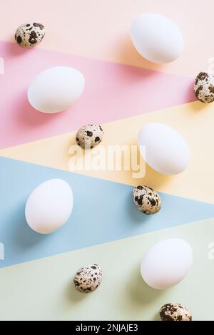 Œufs de poulet blanc et œufs de caille sur fond multicolore Banque D'Images