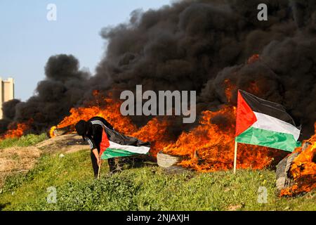 Gaza, bande de Gaza, Palestine. 22nd févr. 2023. Bande de Gaza, Palestine. 22 février 2023. Les Palestiniens brûlent des pneus et lèvent des drapeaux palestiniens lors d'une manifestation dans la région de Malika, près de la frontière orientale de la bande de Gaza. La manifestation a eu lieu pour condamner les raids militaires israéliens fréquents et en cours dans le nord de la Cisjordanie, en particulier à Naplouse et Djénine, effectués sous prétexte d'arrêter des Palestiniens recherchés (Credit image: © Ahmad Haaballah/IMAGESLIVE via ZUMA Press Wire), À USAGE ÉDITORIAL EXCLUSIF ! Non destiné À un usage commercial ! Banque D'Images
