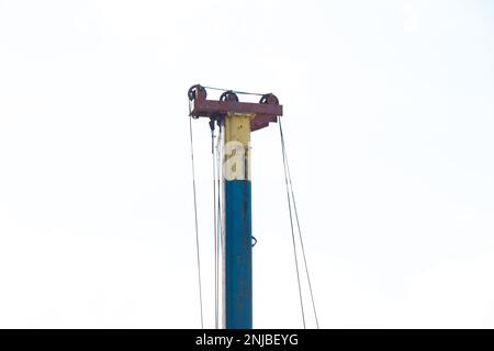 des sabots de grue s'empilent sur la construction d'une maison dans l'après-midi sur la rue Banque D'Images