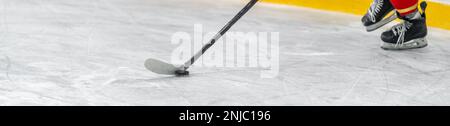 joueur de hockey avec un palet sur un bâton de hockey dans une partie sur glace. bannière avec espace de copie Banque D'Images