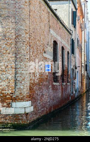 Panneau indiquant le passage des gondoles sur le mur d'un bâtiment en briques surplombant le canal Rio Lustaferi, Cannaregio sestiere, Venise, Italie Banque D'Images