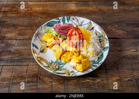 Une assiette de brochettes de poulet cuites sur le gril dans le style moyen-oriental accompagné de légumes grillés et de riz avec sauce Banque D'Images