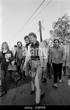 Le candidat à la présidence des États-Unis 1976 est surpassé par la presse le matin du jour de l'élection alors qu'il se promène dans les petites plaines, en Géorgie, sur son chemin pour voter, puis s'arrête devant son bureau d'entrepôt d'arachides. Banque D'Images