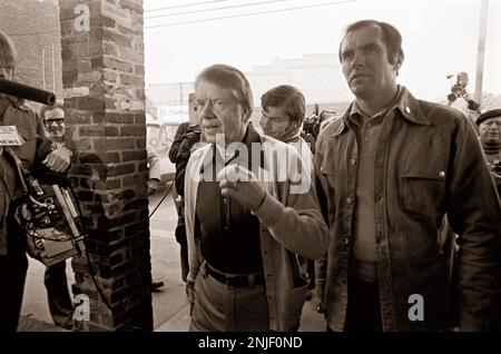 Le candidat à la présidence des États-Unis 1976 est surpassé par la presse le matin du jour de l'élection alors qu'il se promène dans les petites plaines, en Géorgie, sur son chemin pour voter, puis s'arrête devant son bureau d'entrepôt d'arachides. Banque D'Images