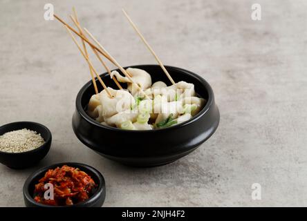 Oemuk Guk ou Odeng Tang, soupe de gâteau de poisson aux brochettes, populaire Korean Street Food. Servi avec Kimchi Banque D'Images