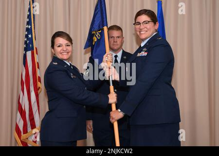 Le Maj. Amber Gasparetto-Brüning, commandant de l'escadron du contrôleur 66th, accepte les lignes directrices des 66 CPT du Col. Taona Enriquez, commandant du Groupe de la base aérienne 66th, lors d'une cérémonie d'accession au commandement à la base de la Force aérienne Hanscom, Mass., août 9, tandis que le Sgt. Blayne Ralston, premier sergent-chef des 66 CPT, regarde. Gasparetto-Brüning remplace le Major Whitney Wade comme commandant. Banque D'Images