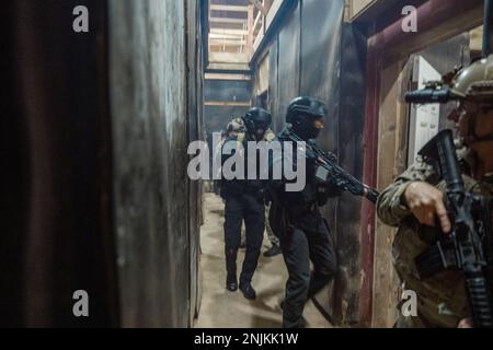 SANTA RITA, Guam (9 février 2023) des marins affectés à l'unité mobile d'élimination des explosifs d'artillerie (EODMU) 5 et des officiers spéciaux de l'application de la loi et des tactiques de la police de l'aéroport de Guam effectuent un exercice de forage raid à bord de la base navale de Guam. L'exercice s'inscrivait dans le cadre d'un exercice de formation sur le terrain axé sur l'amélioration de l'interopérabilité avec les forces de l'ordre locales. EODMU-5 est affecté au commandant de la Force opérationnelle 75, qui exécute le commandement et le contrôle des forces expéditionnaires de la Marine dans la zone d’opérations de la flotte 7th. Ils planifient et exécutent Naval Construction, Expeditionary Logistics, explosif Ordnance Disposa Banque D'Images