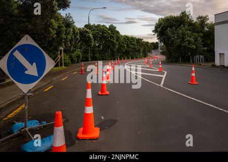 Des cônes de signalisation orange sont alignés sur la route. Carte avec flèche bleue pointant vers la droite pour détourner le trafic. Auckland. Banque D'Images