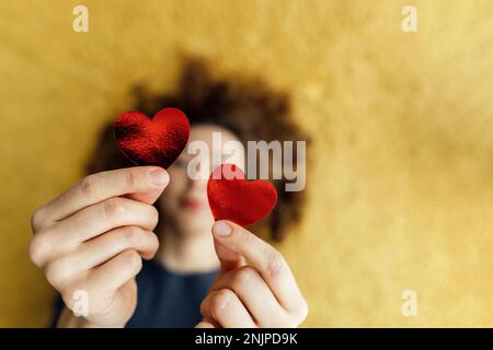 Deux gros coeurs dans les mains qu'une jeune femme donne. Concept donner vie, journée mondiale du coeur, don de sang, défoqué, vue de dessus, style de vie Banque D'Images