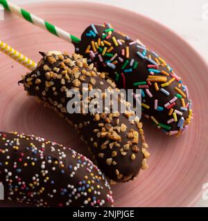 Bananes enrobées de chocolat noir et recouvertes de caramel décoratif. Banque D'Images