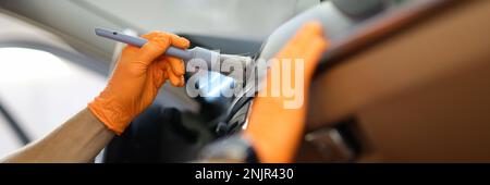 Le réparateur maître nettoie le climatiseur de la voiture avec une brosse à la fermeture de l'atelier Banque D'Images