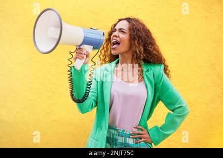 Mégaphone, femme et criant sur fond jaune de discours, de diffusion et de bruit de protestation. Femme, annonce et cri voix pour la justice, nouvelles Banque D'Images
