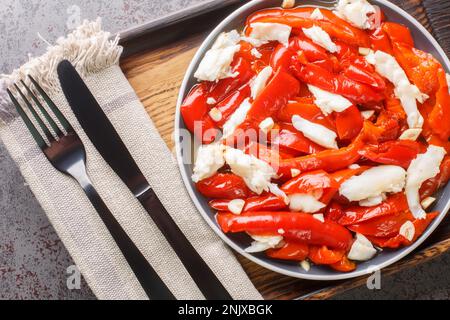 Esgarraet la salade de morue et de poivron rouge est un plat valencien typique qui se trouve sur l'assiette en bois. Vue horizontale du dessus Banque D'Images