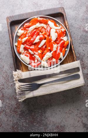 Poivrons rouges et cabillaud poisson esgarraet tapas de l'Espagne près de l'assiette sur la table. Vue verticale du dessus Banque D'Images