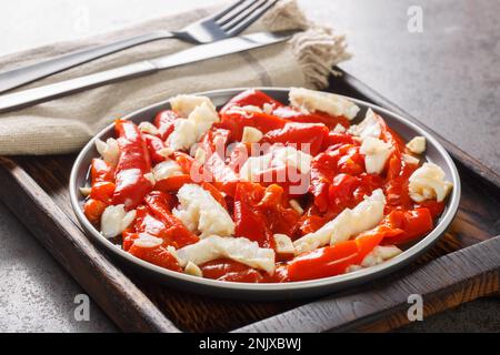 Esgarraet la salade de morue et de poivron rouge est un plat valencien typique qui se trouve sur l'assiette en bois. Horizontale Banque D'Images