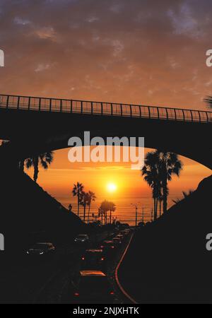 Pont de Villena avec circulation et vue partielle sur la ville au coucher du soleil de fond, Lima, Pérou. Banque D'Images