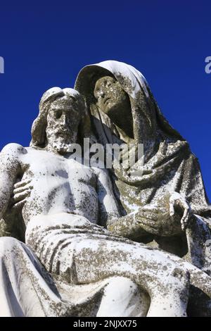 Une statue en pierre naturelle réplique de la célèbre Pieta de la Vierge Marie de Michel-Ange tenant le corps de son fils Jésus. Banque D'Images