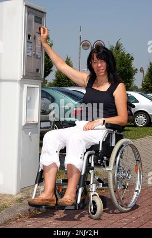 femme en fauteuil roulant au guichet de stationnement Banque D'Images