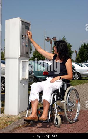 femme en fauteuil roulant au guichet de stationnement Banque D'Images