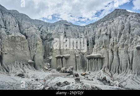 Paysage majestueux de collines rugueuses avec surface inégale et pierres sur le sable sous ciel bleu nuageux dans le désert de Tatacoa en Colombie Banque D'Images