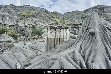 Paysage majestueux de collines rugueuses avec surface inégale et pierres sur le sable sous ciel bleu nuageux dans le désert de Tatacoa en Colombie Banque D'Images