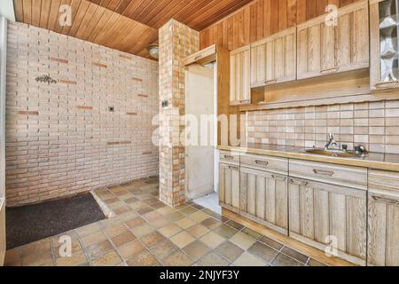 Décoration intérieure de cuisine rustique avec mobilier en bois et appareils modernes avec cuisinière et hotte Banque D'Images