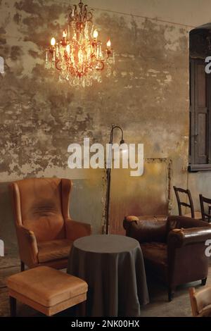 un groupe de chaises différentes placées sous le lustre dans un café pop up Banque D'Images
