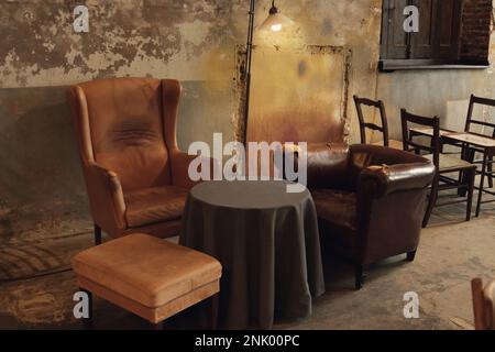 style varié de chaises réunies pour mettre en place le café dans un bâtiment abandonné Banque D'Images