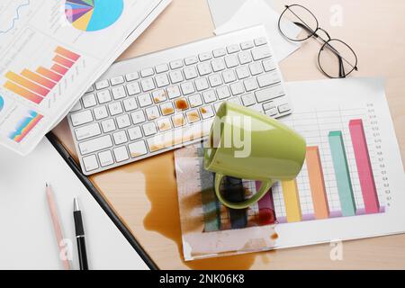 Tasse de café renversé sur le clavier d'ordinateur sur le bureau en bois, au-dessus de la vue Banque D'Images