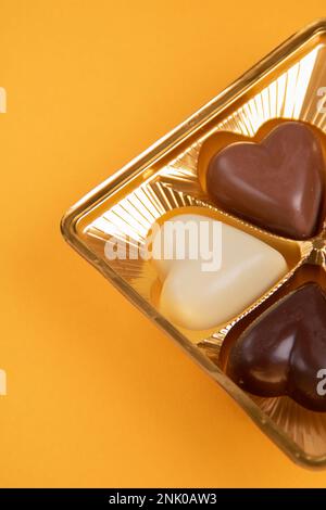 chocolats photo en forme de cœur dans un paquet sur fond jaune Banque D'Images