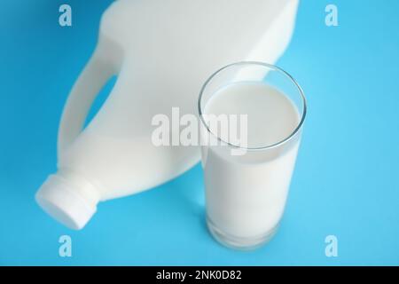 Bouteille de lait et verre de gallon sur fond bleu clair Banque D'Images