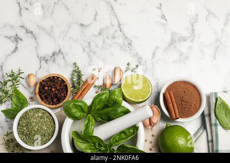 Différentes épices naturelles et herbes sur table en marbre blanc, plat. Espace pour le texte Banque D'Images