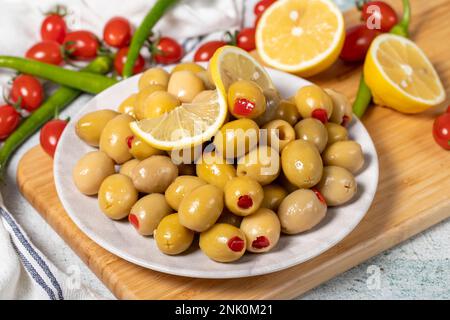 Olives vertes remplies de poivron rouge. Olives farcies sur une table de service en bois. Gros plan Banque D'Images