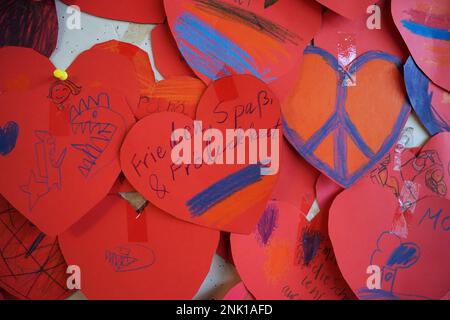 Hambourg, Allemagne. 23rd févr. 2023. Les coeurs rouges avec les symboles de paix et les souhaits des élèves de l'école élémentaire Molkenbuhrstraße sont accrochés à un conseil dans le bâtiment de l'école. Le 24 février 2023 marque le premier anniversaire de la guerre d'agression russe contre l'Ukraine. Credit: Marcus Brandt/dpa/Alay Live News Banque D'Images